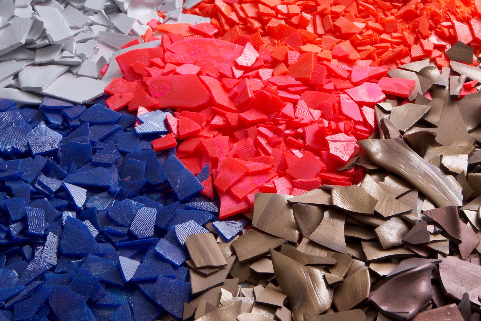 Sorted powder chips in blue, red, grey and bronze, collected for recovery